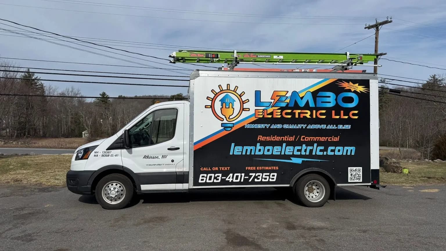 Side profile of a white Lembo Electric LLC box truck with a blue and orange wrap, green ladder on the rack, parked on pavement under a partly cloudy sky.