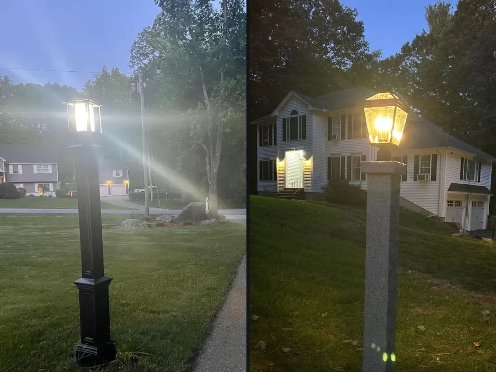 Two lamp posts at dusk: a black post light glowing beside a paved driveway, and a lantern on a granite post lighting a sloped front lawn before a white colonial.