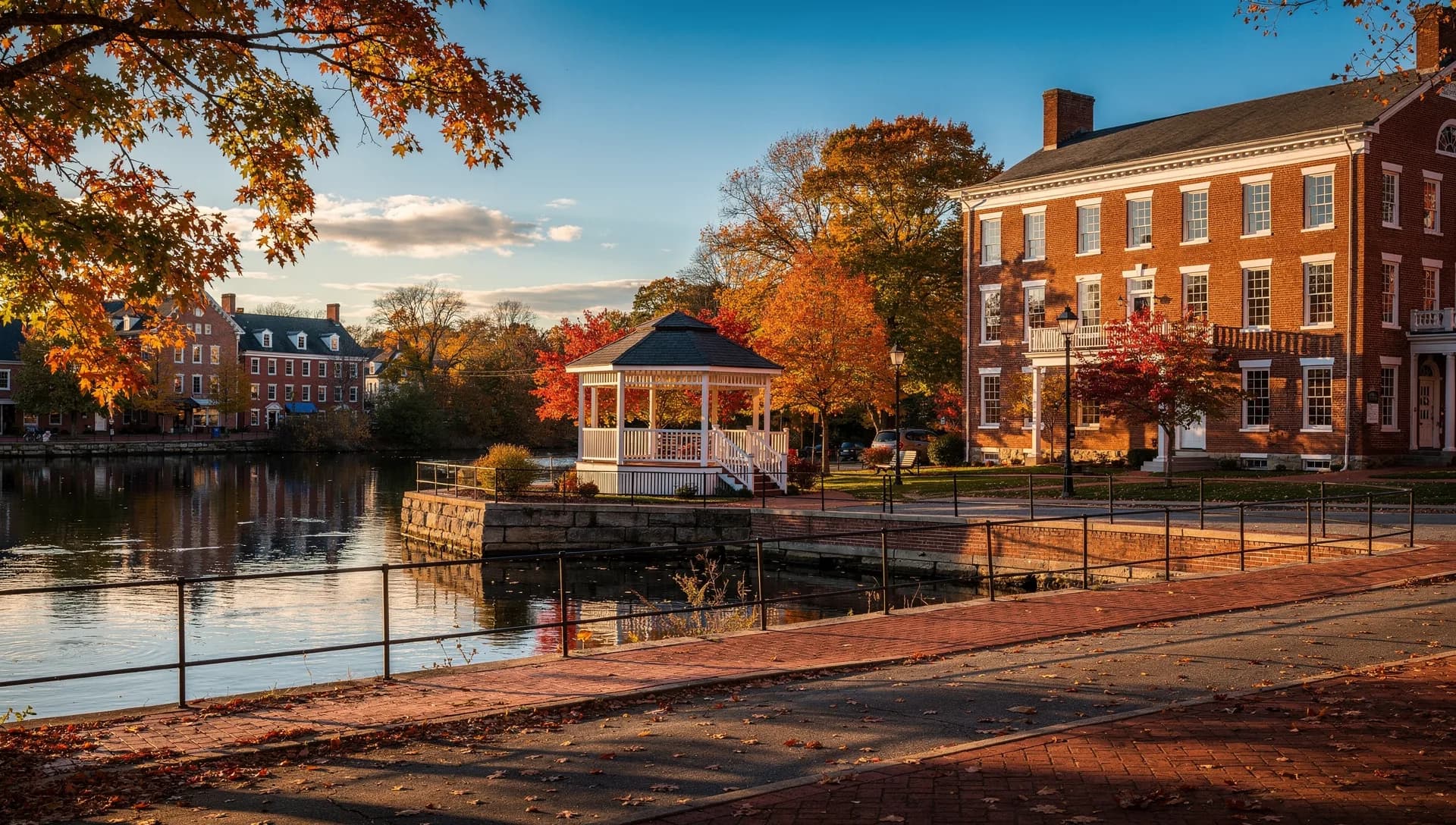Brick storefronts and a historic bandstand in downtown Exeter, New Hampshire, beside the Squamscott River.